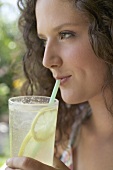 Young woman drinking lemonade through a straw