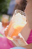Woman drinking a glass of iced tea