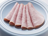 Several slices of ham on light blue plate
