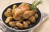 Chicken with roast potatoes in a frying pan