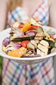 Woman holding a plate of grilled vegetables