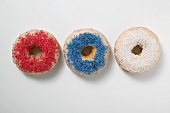 Three doughnuts with sprinkles (red, blue, white)