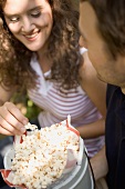 Couple eating popcorn at a picnic