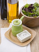 Salt, small green jug, oil, vinegar and leaf salad