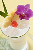Piña Colada with pineapple, cocktail cherry and orchid