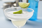 Margarita with lime wedges in a glass with a salted rim