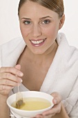 Frau mit weißem Handtuch und Schale Tee
