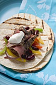 Fajita with beef, beans, peppers and sour cream