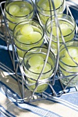 Glasses of water with green grapes in a glass carrier