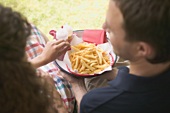 Couple eating chips in garden
