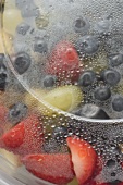 Fruit salad in plastic container (close-up)