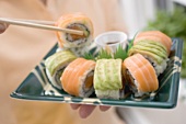 Woman holding sushi platter with soy sauce