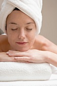 Woman lying down, resting on white towel