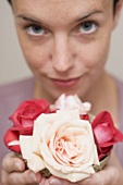 Frau hält Schale mit Rosenblüten