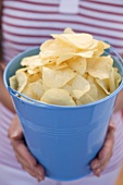 Woman holding crisps in blue bucket