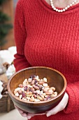 Woman holding wooden bowl of nuts (Christmas)