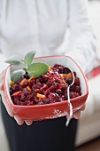 Woman holding dish of cranberry sauce