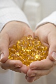 Hands holding vitamin capsules