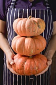 Woman holding three pumpkins