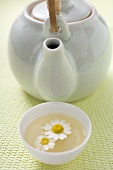 Teapot and bowl of chamomile tea