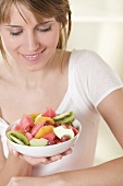 Woman holding dish of fruit salad
