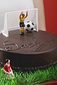 Woman holding Sacher torte with football figures