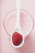 Raspberry shake with spoon & fresh raspberry (overhead view)