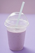 Blueberry shake in plastic cup with straw