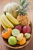 Exotic fruit and citrus fruit in wooden bowl