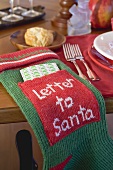 Stocking with letter to Santa Claus, beside Xmas place-setting