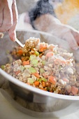 Making bread stuffing: folding in vegetables