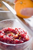 Grating orange zest into cranberry sauce
