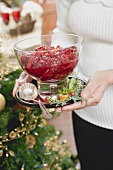 Woman holding bowl of cranberry sauce (Christmas)