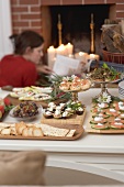 Assorted appetisers on table in front of fireplace (Christmas)