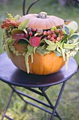Pumpkin decorated with flowers on garden table