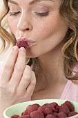 Woman kissing fresh raspberry