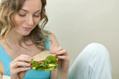 Woman holding wholemeal avocado and watercress sandwich