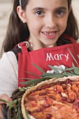 Girl holding freshly-baked apple and cranberry tart