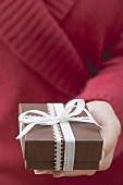 Woman holding gift box with ribbon