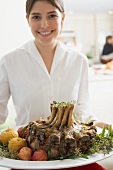Young woman serving rack of pork for Christmas