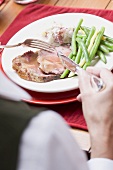 Woman eating roast turkey with green beans (Christmas)