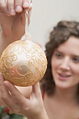 Woman holding gold Christmas bauble