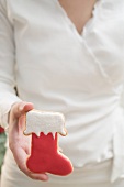 Woman holding Christmas biscuit (red boot)