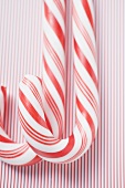Two candy canes on striped background