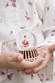 Small girl holding Christmas snow globe