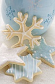 Iced Christmas biscuits in front of blue cup