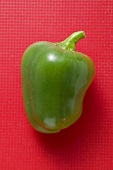Green pepper on red background