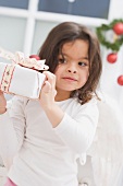 Kleines Mädchen hält Weihnachtspäckchen