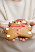 Child holding gingerbread teddy bear