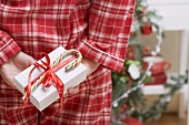 Woman hiding Christmas gift behind her back